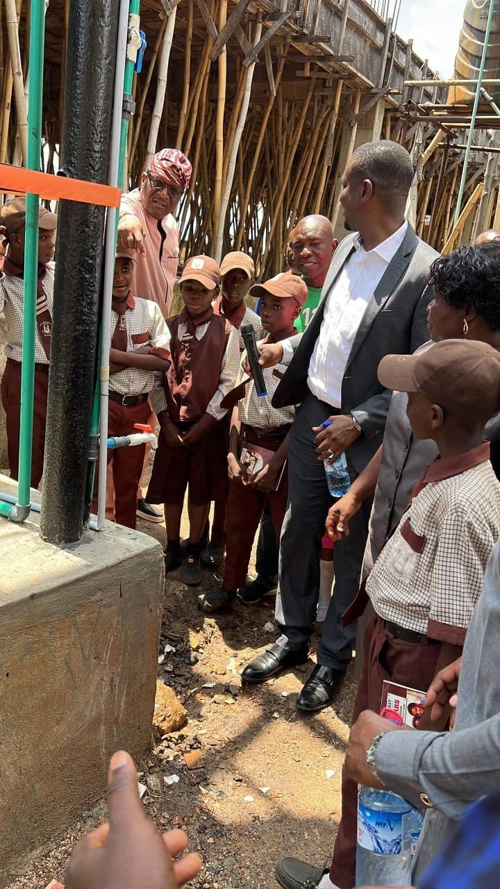 Students gathered around the new water dispensing point as a member addresses them